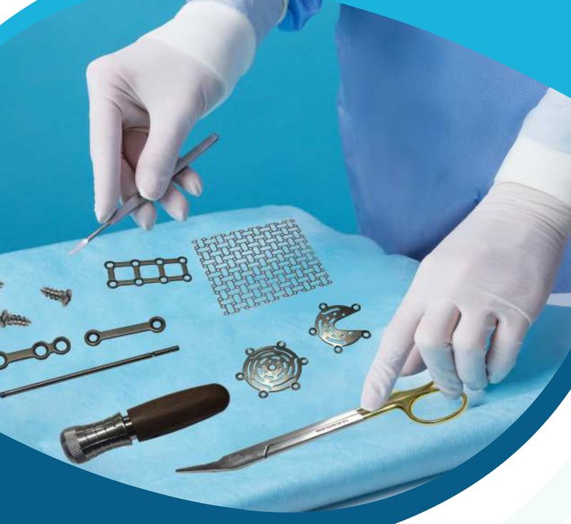 Gloved hands laying out Loyal Surgicals plates, screws, mesh and instruments on a sterile field
